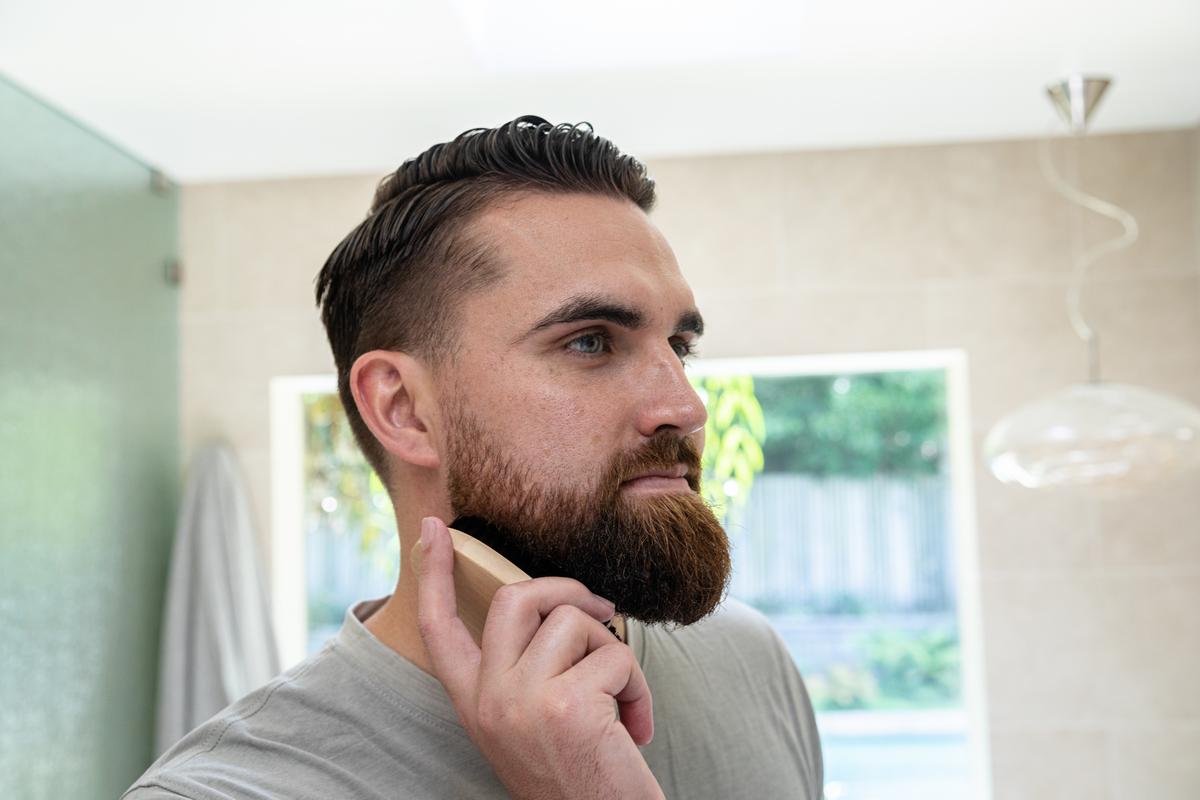Man grooming his beard in a bathroom setting