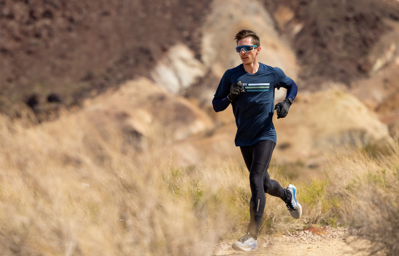 Athlete running on a trail in a natural landscape