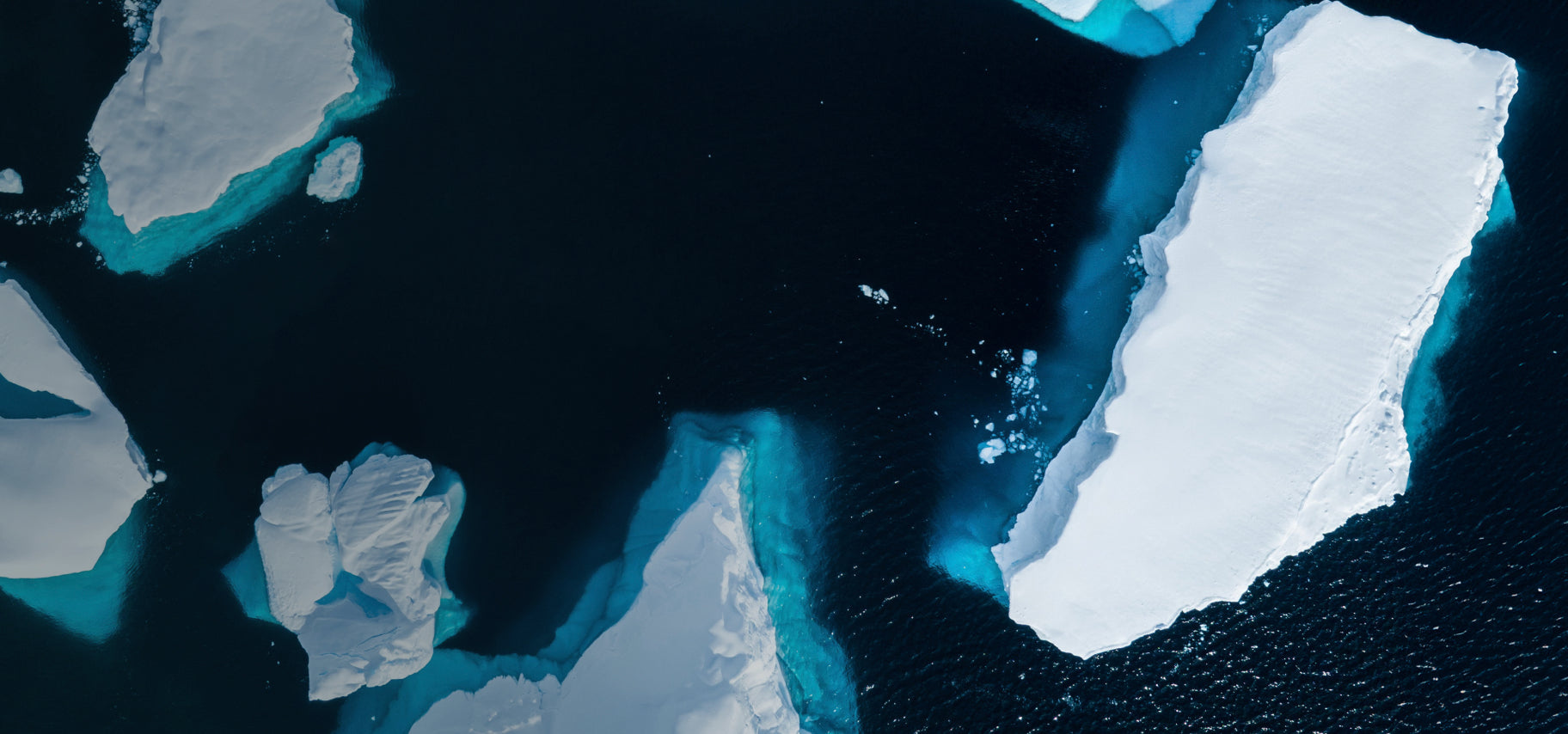 Aerial view of icebergs in dark water, representing the Cold Plunge soap inspiration.