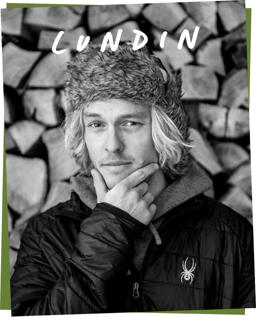 Lundin, a brand ambassador, posing thoughtfully in front of stacked wood.