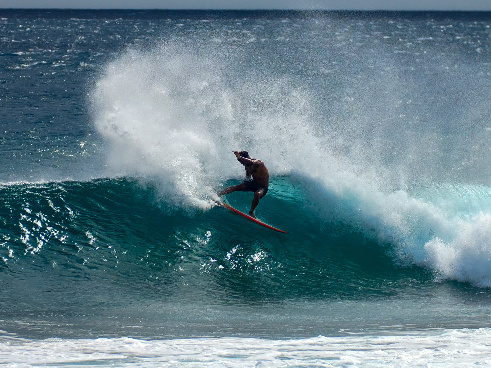 A surfer performing a maneuver on a wave in the ocean.