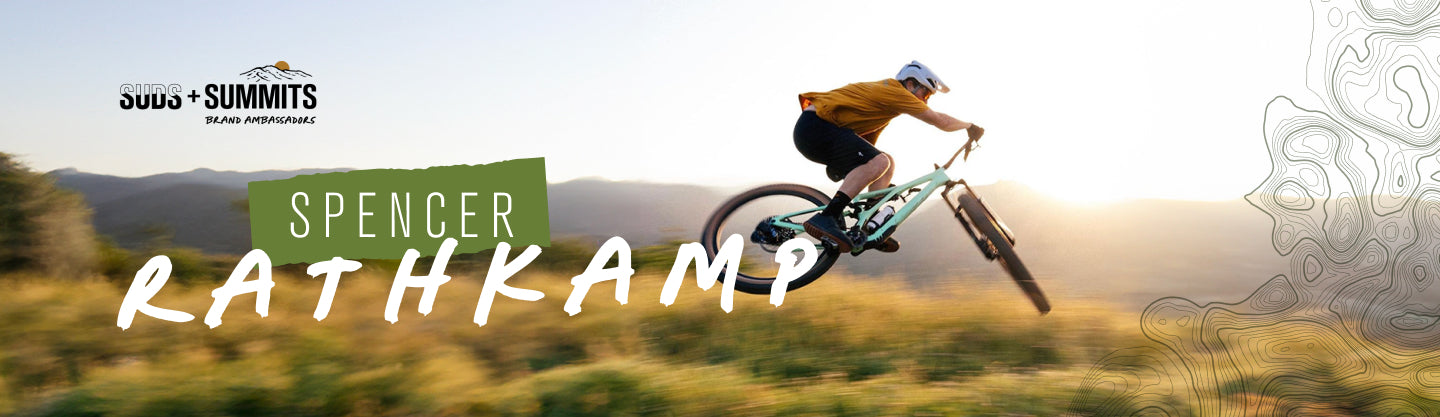 Spencer Rathkamp biking on a mountain trail with the text 'SPENCER RATHKAMP' overlayed.