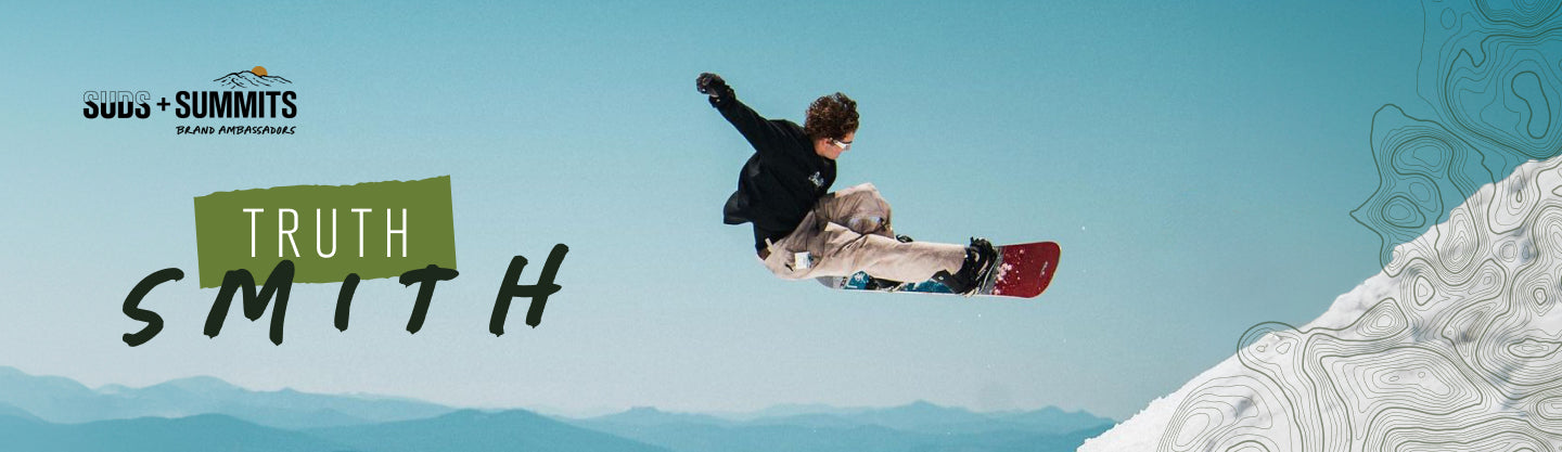 Truth Smith performing a snowboarding trick against a mountain backdrop.