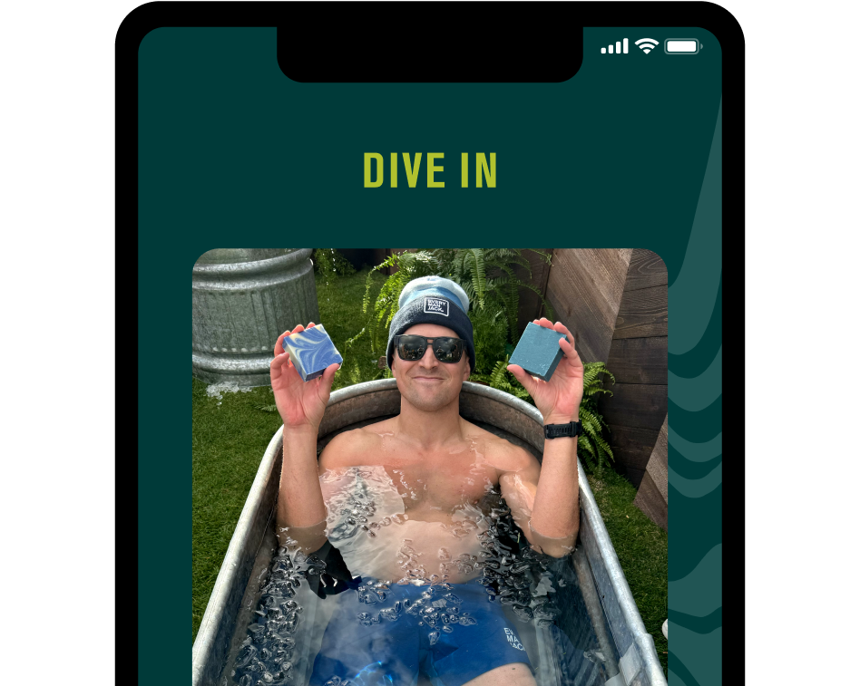 A person in a tub holding two blue Cold Plunge bar soaps.