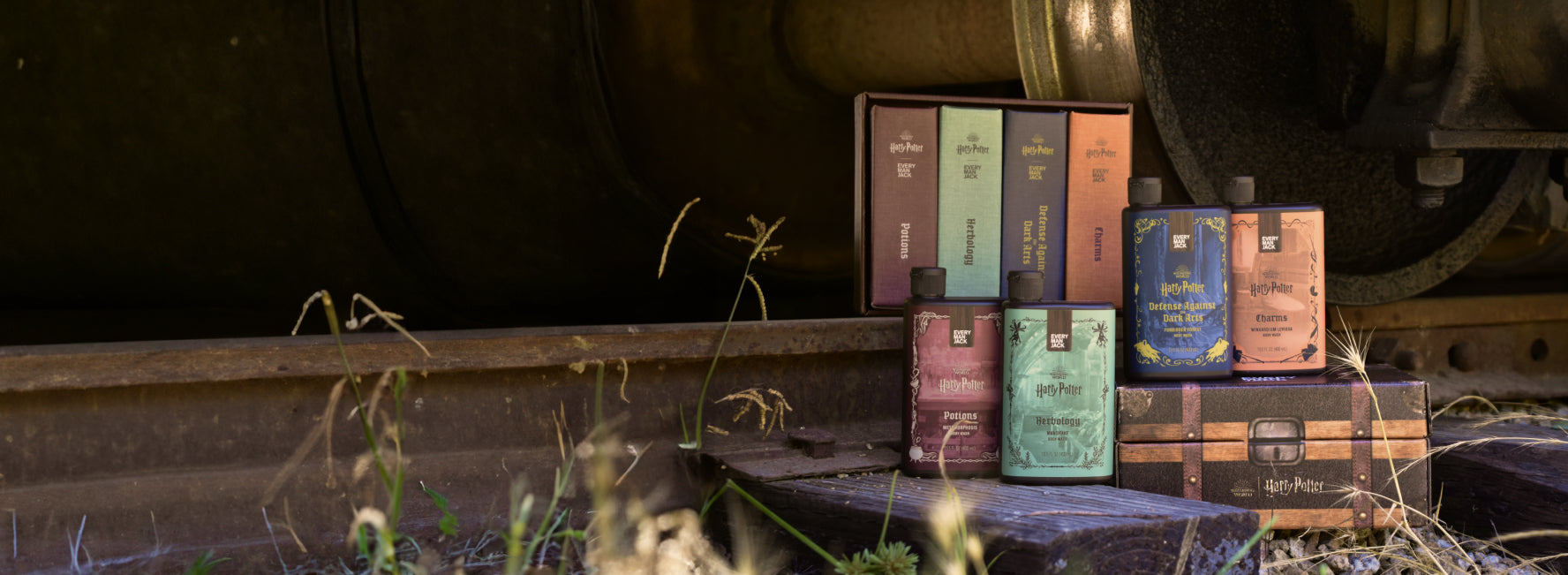 A collection of body wash bottles in different colors and scents displayed outdoors.