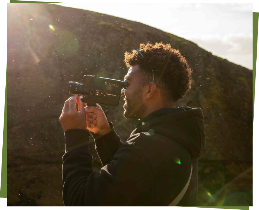 Hunter Jones filming outdoors with a camera, capturing his surfing adventures.