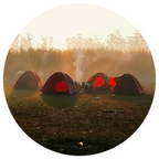 Four camping tents with glowing interiors in a natural setting at sunset.