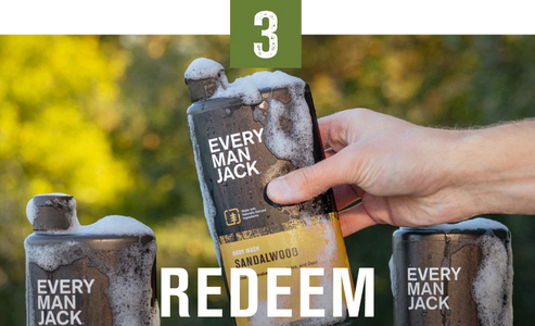 A hand holding a bottle of Every Man Jack body wash with the label 'Sandalwood' and the word 'REDEEM' in bold letters.