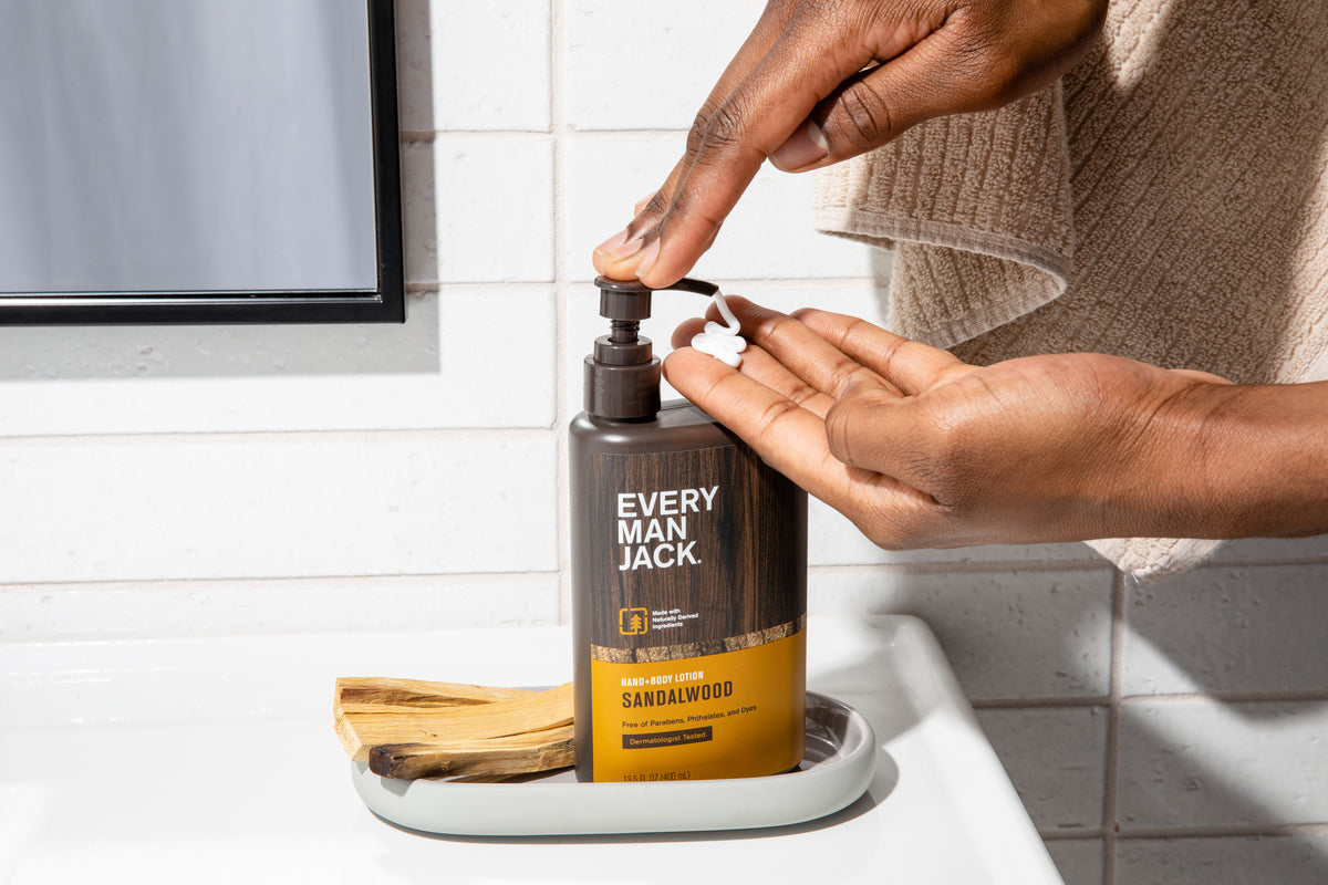 Person dispensing Every Man Jack Sandalwood lotion into their hand in a bathroom