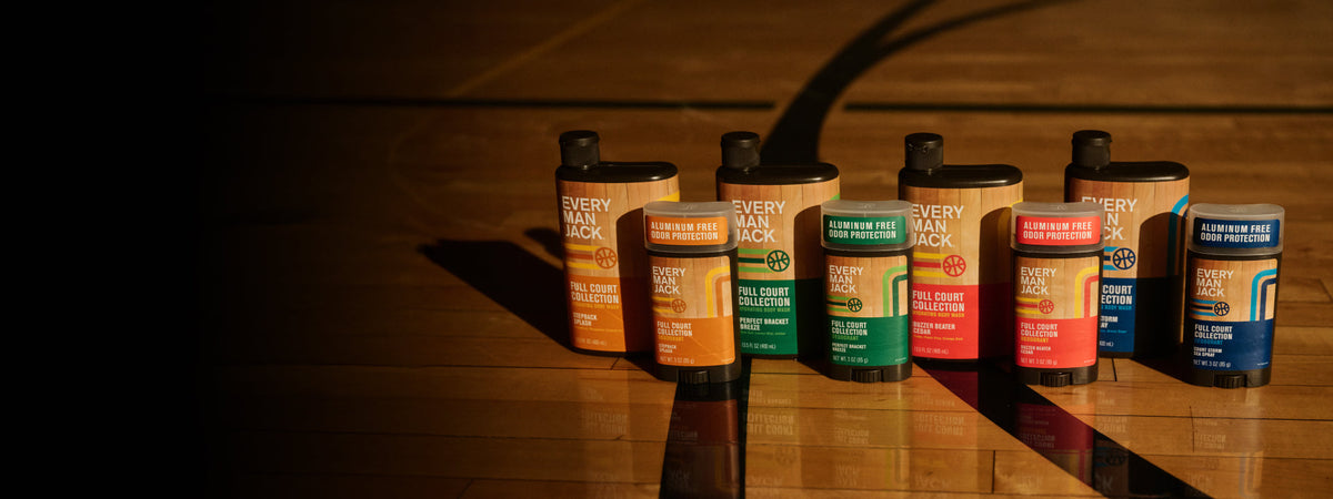 Front view of limited-edition deodorants and body wash, aluminum-free, in colorful basketball-themed packaging on hardwood court