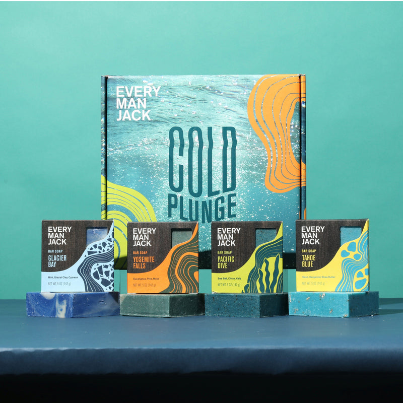 Four Every Man Jack bar soaps labeled Glacier Bay, Yosemite Falls, Pacific Dive, and Tahoe Blue, each on a matching soap bar, in front of a large box labeled 'Every Man Jack Cold Plunge'.
