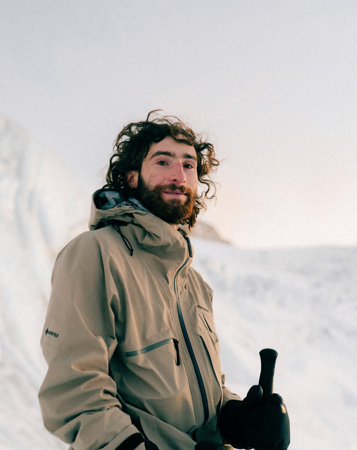 Man in a beige jacket standing in a snowy landscape