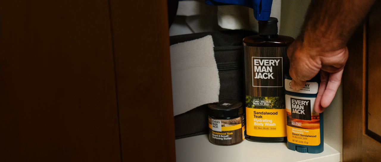 Hand selecting Every Man Jack deodorant from a cabinet.
