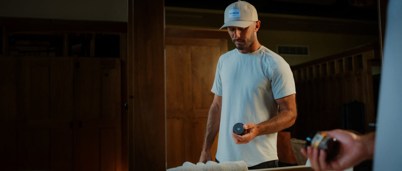 Max Homa in a white t-shirt and cap holding Every Man Jack beard product