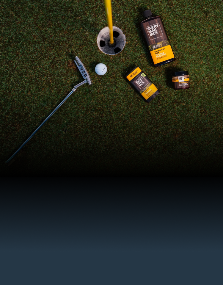 Golf club, golf ball, and 'Every Man Jack' products on a grassy surface