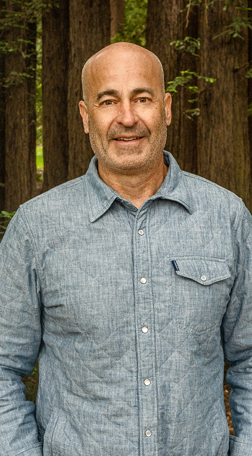Man wearing a blue shirt standing in a forest