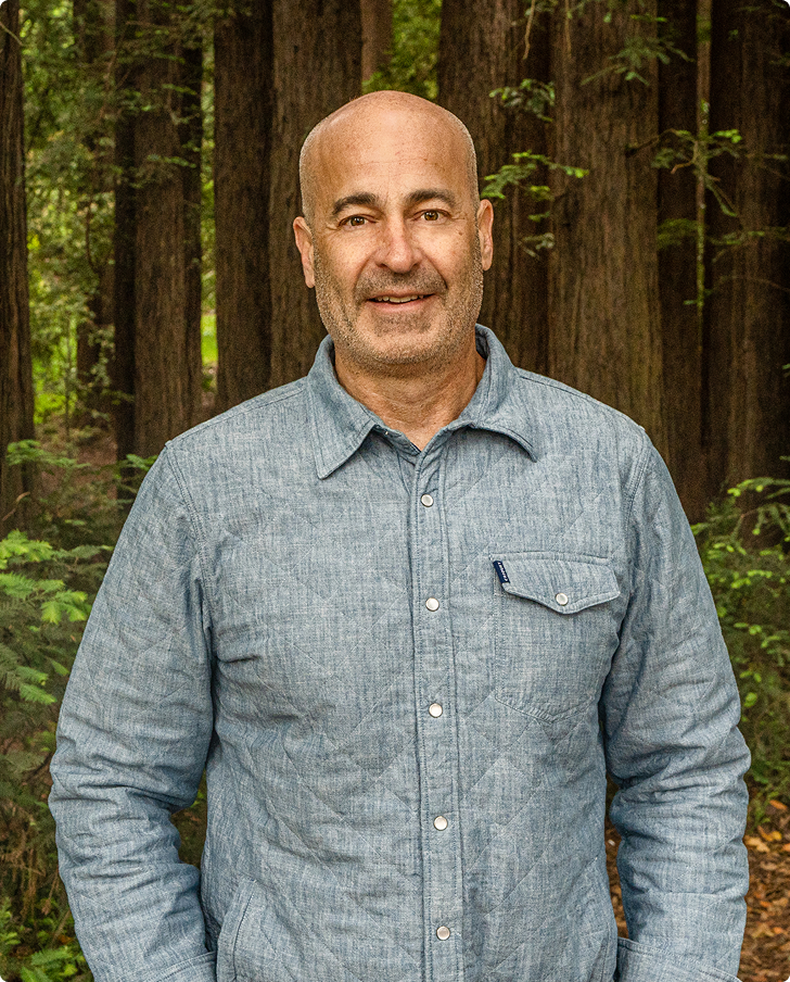 Man wearing a blue shirt standing in a forest