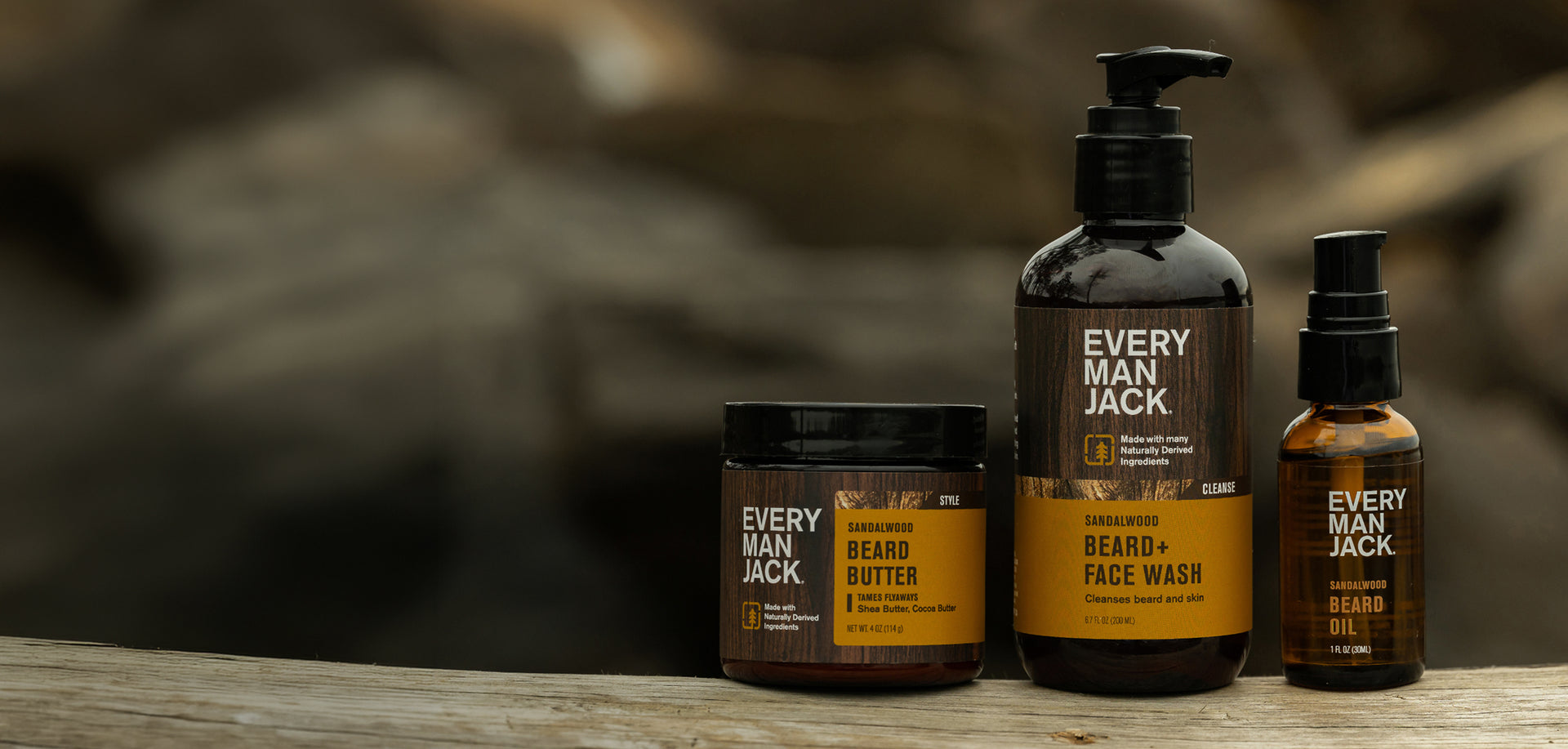 Front view of three Every Man Jack sandalwood products on wood: Beard Butter, Beard and Face Wash, and Beard Oil