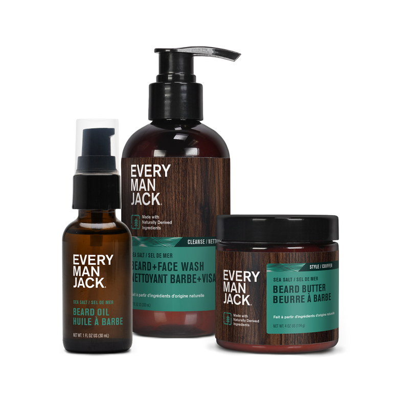 Three Every Man Jack grooming products: Beard Oil, Beard + Face Wash, and Beard Butter, each with distinct packaging and labels.